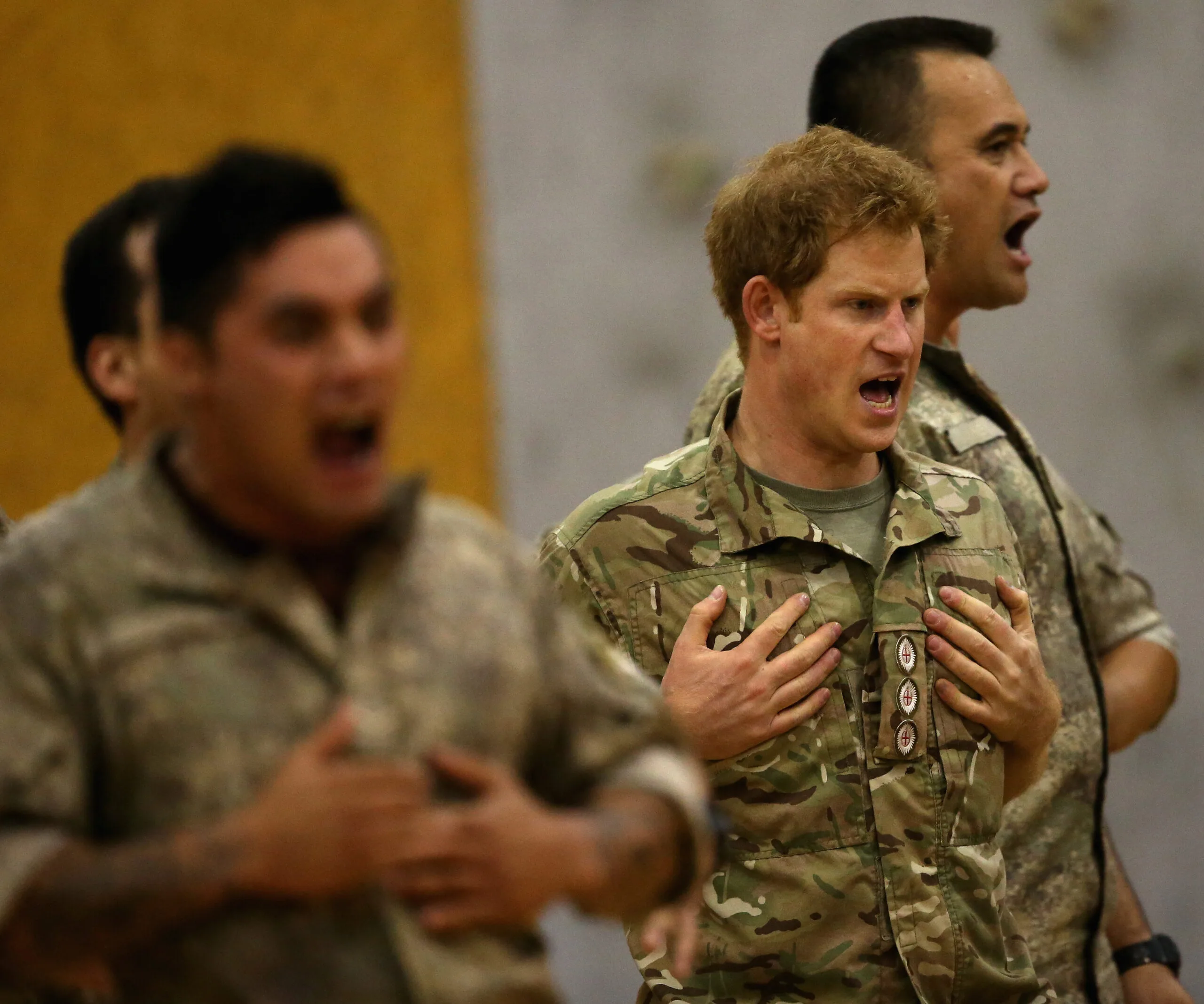 Prince Harry participates in a haka with soldiers in military uniforms in New Zealand.