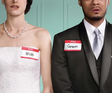 Bride and groom standing side by side, wearing formal attire with name tags reading "Bride" and "Groom".