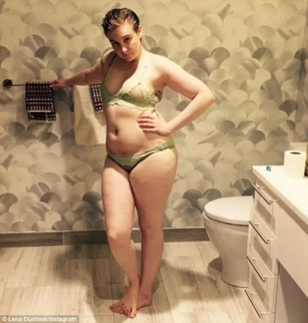 A woman poses confidently in a bathroom wearing a light green lingerie set.