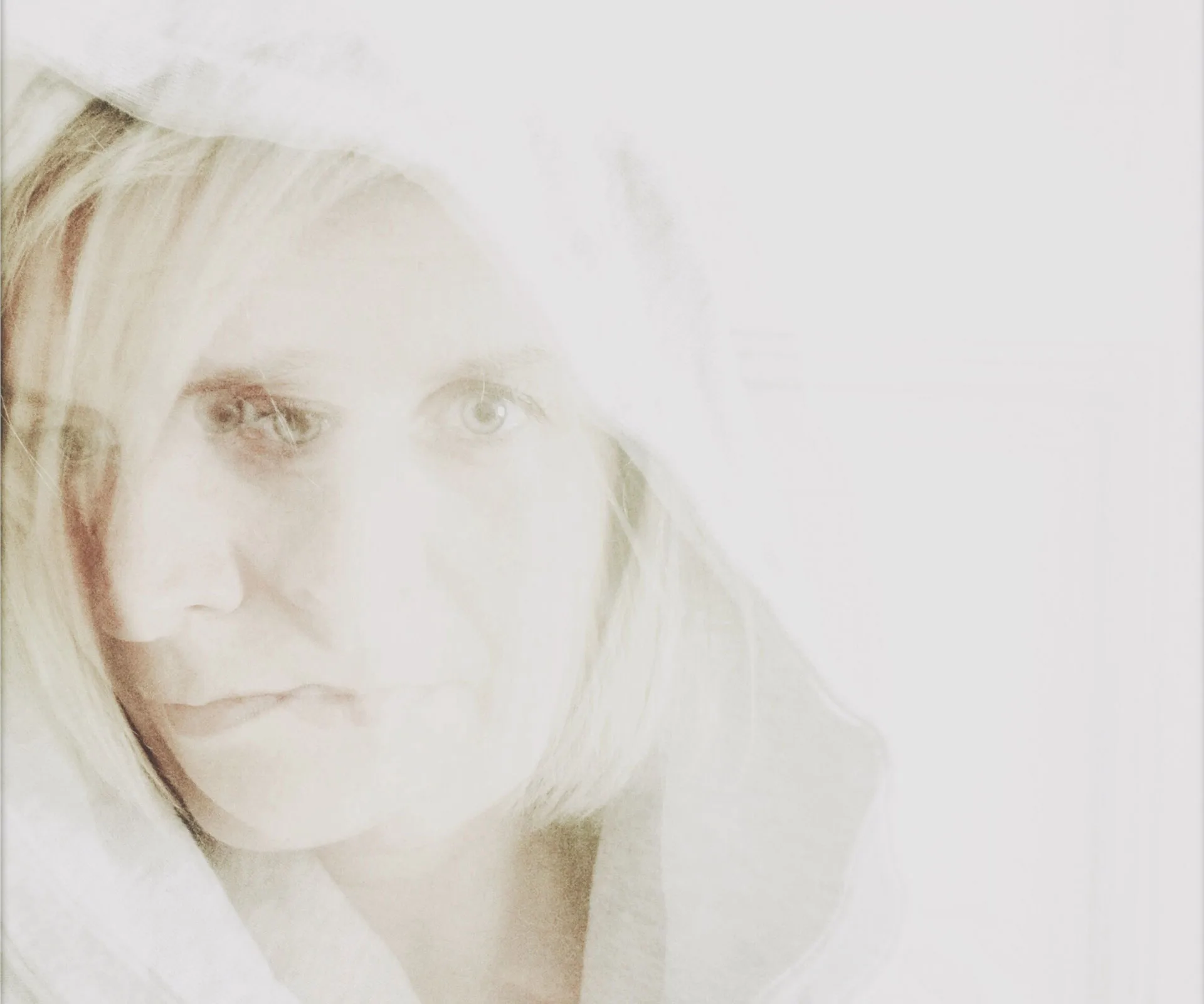 A woman with a hooded white robe, semi-transparent in a ghostly artistic overlay.