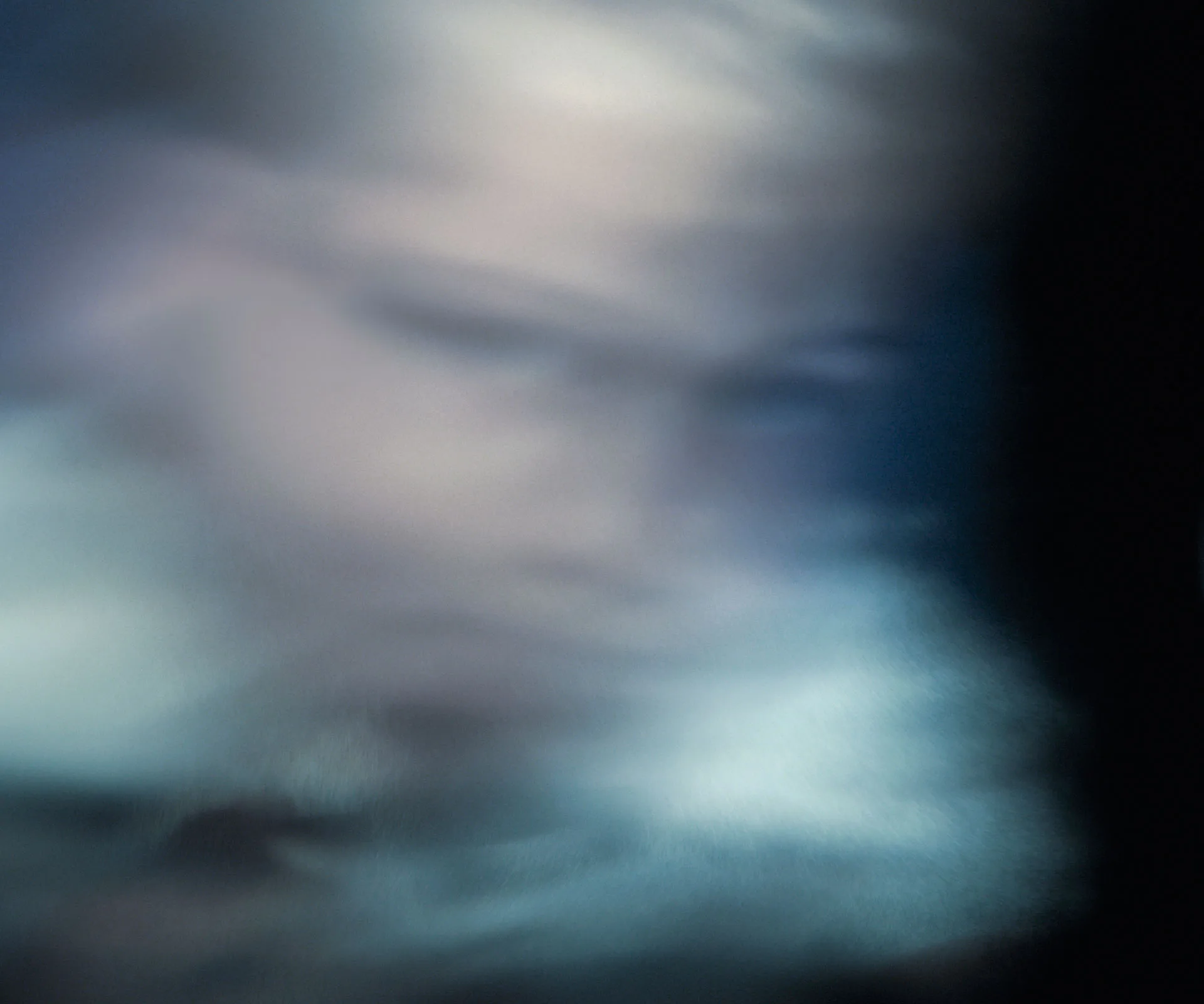 Blurred, ghostly figure with indistinct features against a dark, misty background.