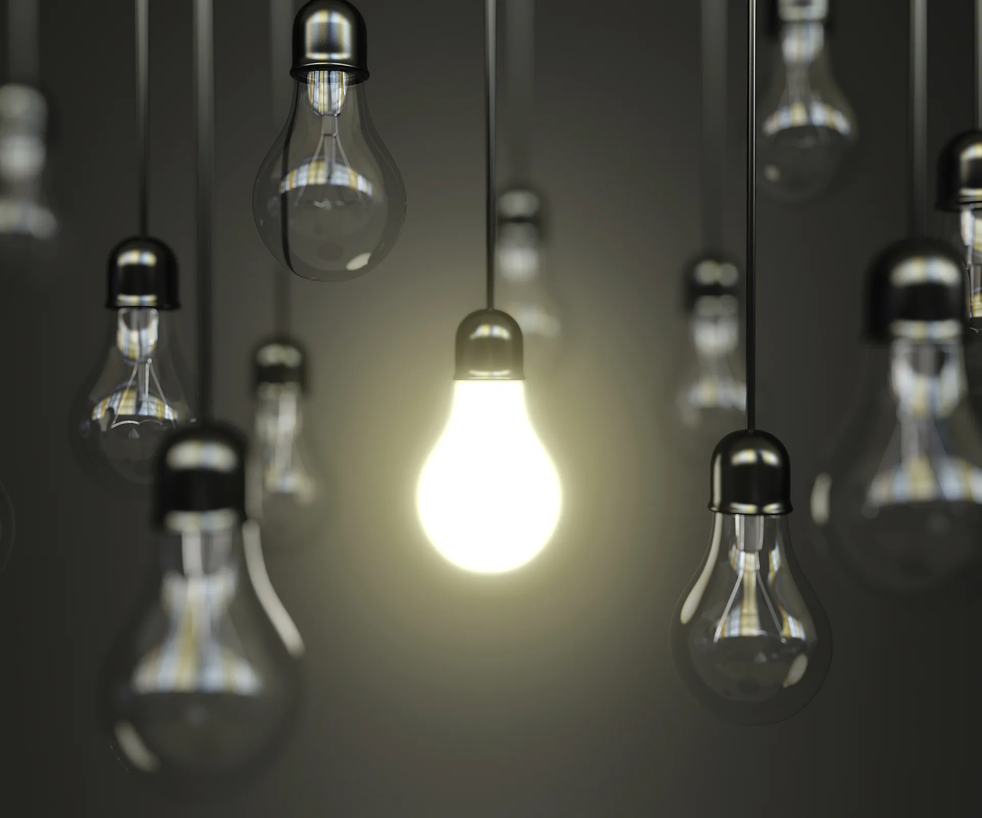 Alt text: "Brightly lit bulb among several dim ones, symbolizing discovery or innovation."