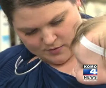 Woman holding a baby close, KOMO 4 News logo in the bottom right corner.