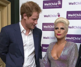 Two individuals posing together at a WellChild charity event, one in a suit, the other in a sequined dress.