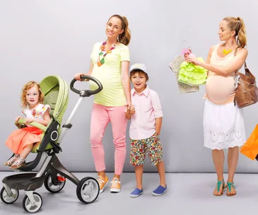 A pregnant woman with a stroller, a young girl, and a boy holding hands, while another woman holds clothes.
