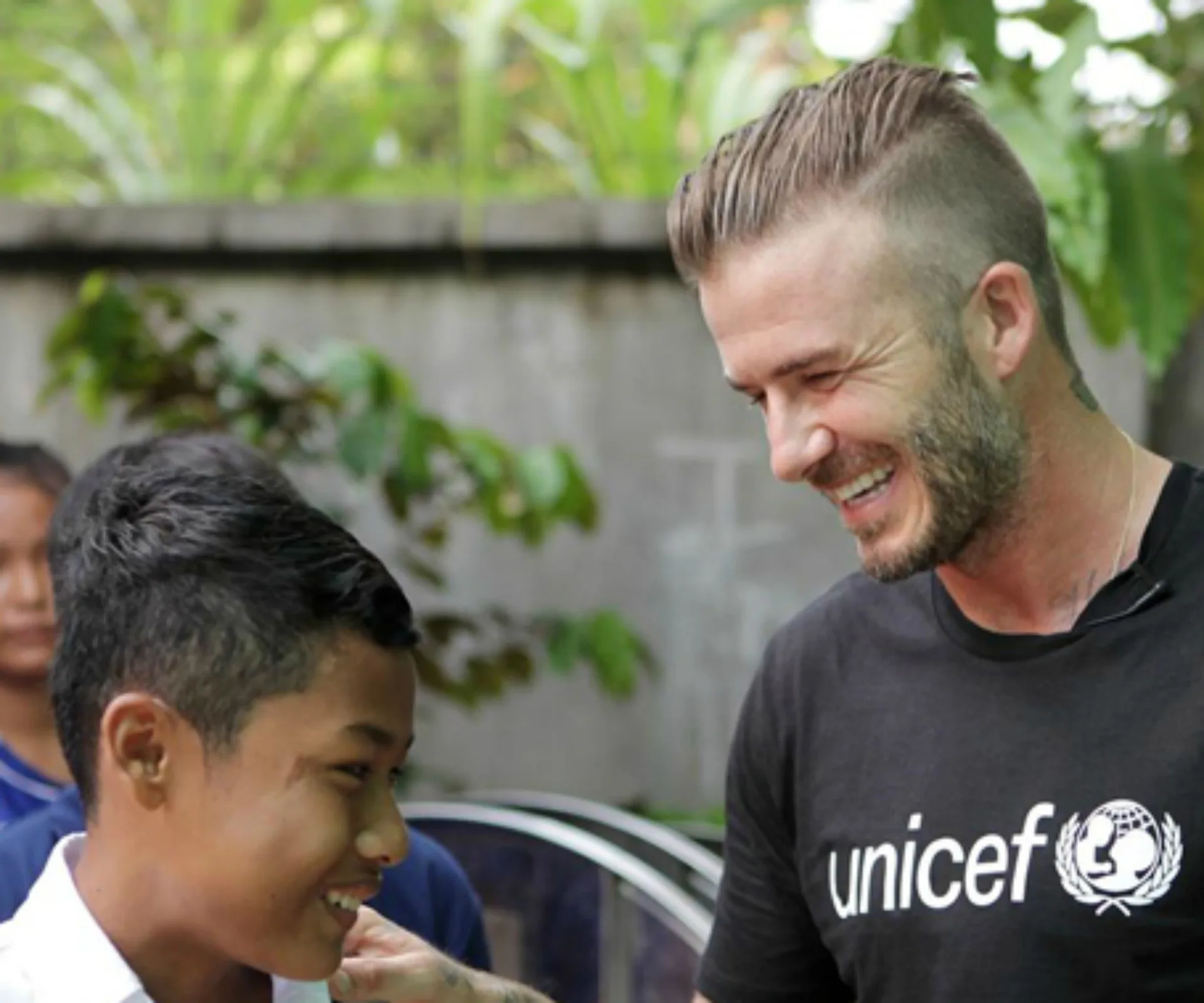 David Beckham smiles with a child during a UNICEF visit to Cambodia.