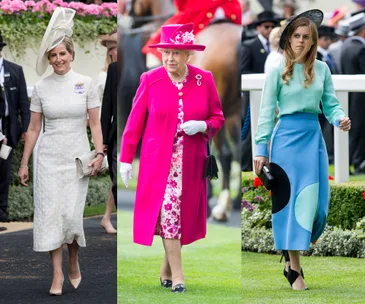 Three women dressed elegantly at Royal Ascot, each in colorful outfits and hats, walking on a grassy path.