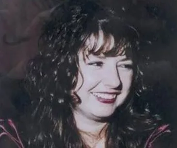 A woman with curly hair smiling.