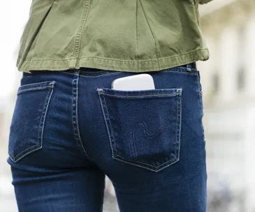 Person in tight skinny jeans with phone in back pocket.