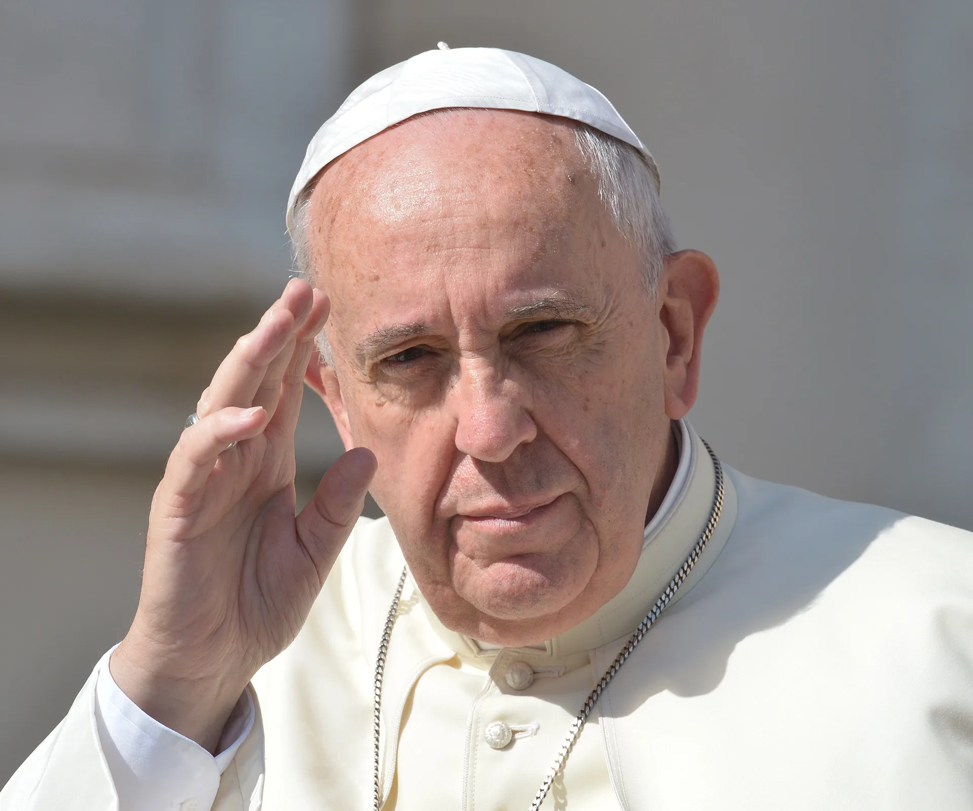 I don't know who this is. The image shows an elderly man in white attire and a hat, gesturing with his right hand.