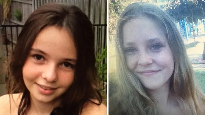 Two young girls smiling; one with dark brown hair and one with light brown hair, outside in natural settings.