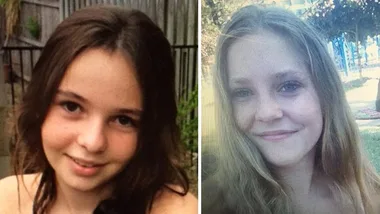 Two young girls smiling; one with dark brown hair and one with light brown hair, outside in natural settings.