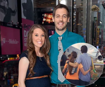 ```html
<img src="https://www.etonline.com/sites/default/files/styles/1920xh/public/images/2023-09/GettyImages-484473053.jpg?itok=kEMOprKw" alt="A smiling couple poses in an urban setting, inset shows a couple embracing near a plane." />
```