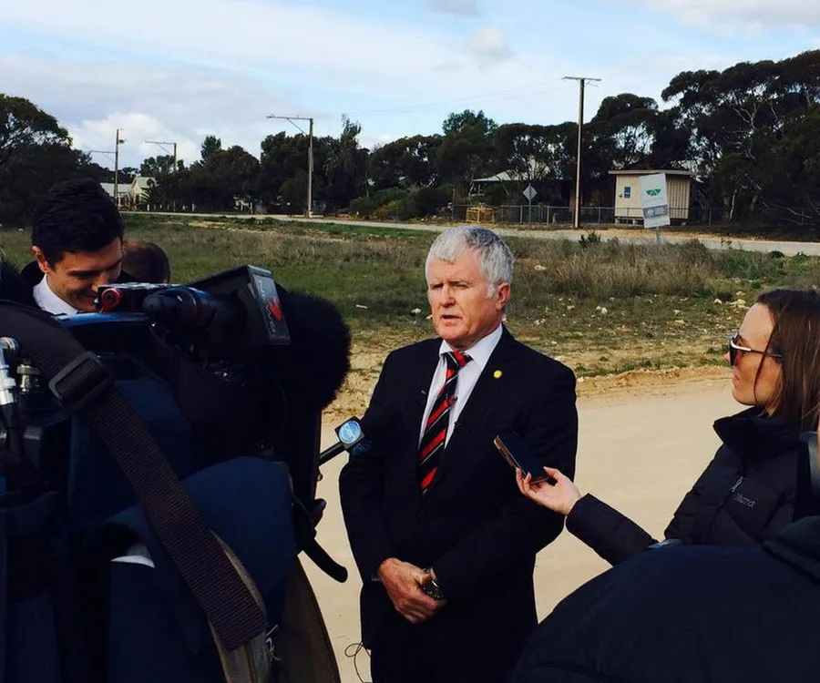 Police spokesperson giving a statement outdoors surrounded by media and cameras.