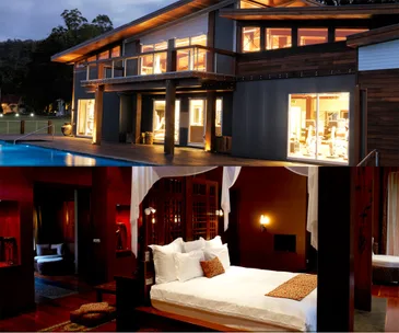 Luxury retreat showing a modern gym and an elegant, warmly lit bedroom with a canopy bed.
