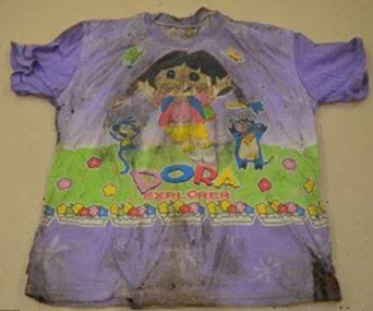 Dirty children's T-shirt with a 'Dora the Explorer' print on a beige background.