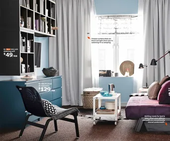 Modern living room with IKEA furniture: KALLAX shelving unit, MALM chest, chair, sofa, and window with white curtains.