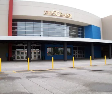 Front view of The Grand movie theater with multiple entrances and bright accents.