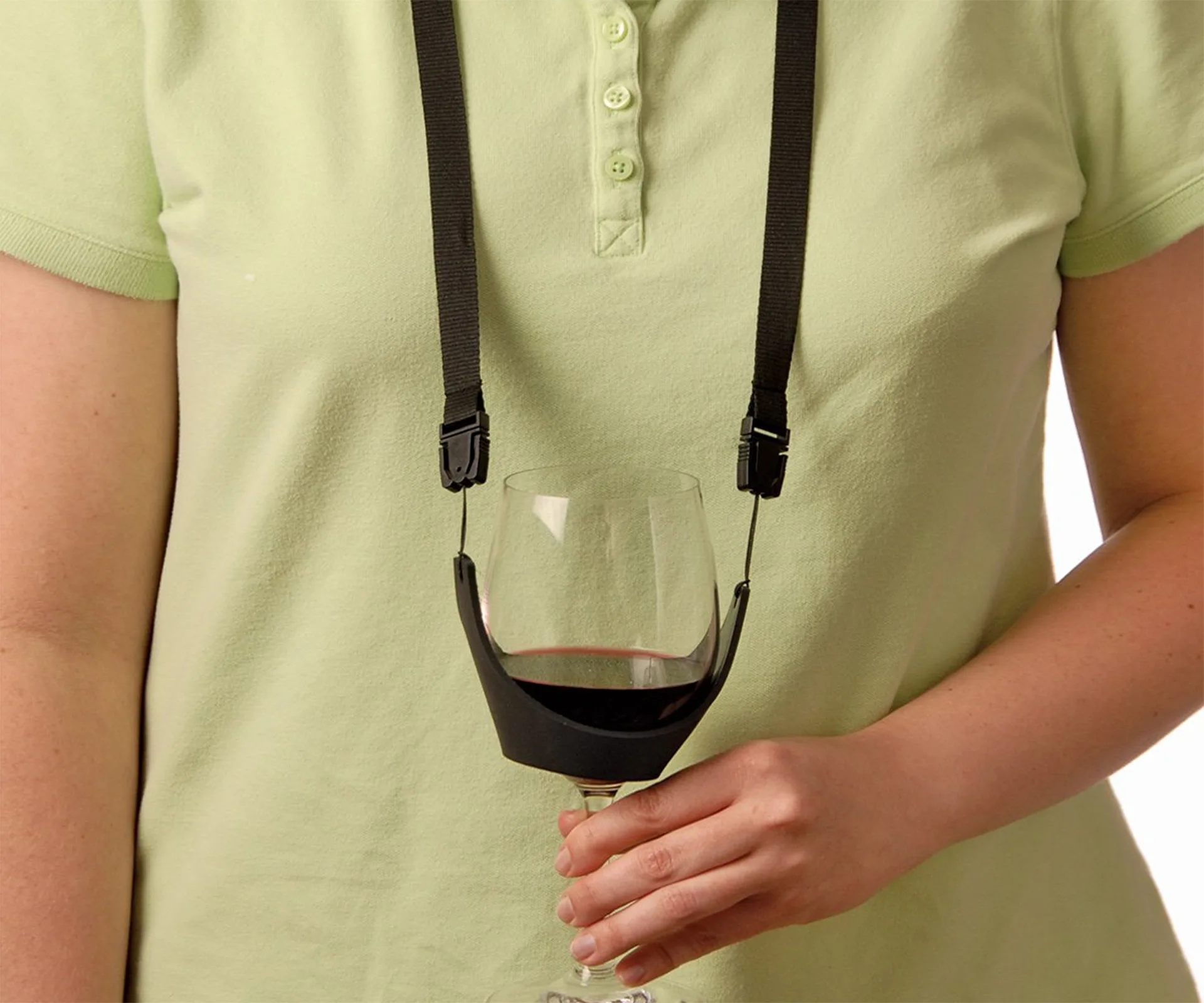 A person wearing a wine glass holder necklace that supports a glass of red wine.