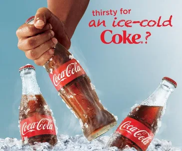 Hand grabbing an ice-cold Coca-Cola bottle from ice, with two more bottles and text "thirsty for an ice-cold Coke?"