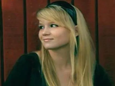 I don't know who this is, but a young woman with long blonde hair looks to the side, wearing a black headband and top.