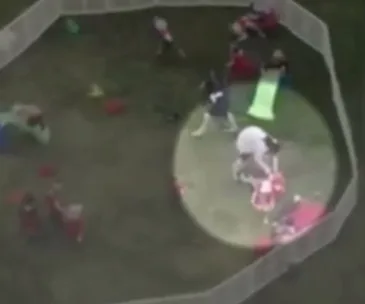 Aerial view of a childcare play area with toddlers and adults, highlighted section showing interaction.