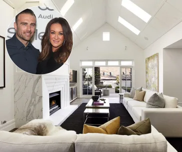 Spacious living room with high ceiling, modern decor, large windows, and inset: two people smiling at an event.