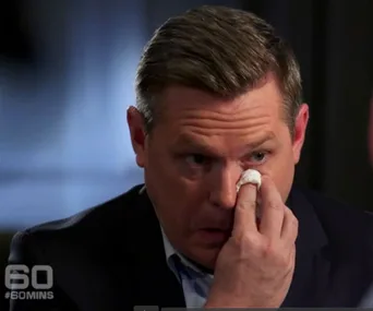Man in suit wiping tears with tissue, appearing emotional, "#60MINS" logo visible in corner.