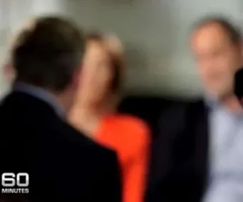 Blurred image of three people in a discussion on "60 Minutes".