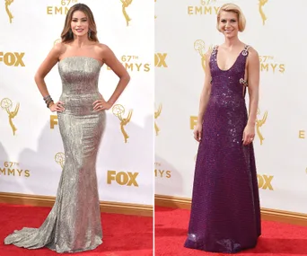 Two women on the red carpet at the 67th Emmy Awards, wearing strapless silver and V-neck purple gowns.
