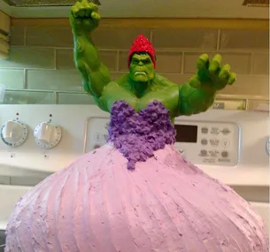 A Hulk figure in a purple and pink dress modeled as a cake on a kitchen stovetop.