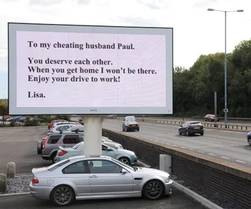 Billboard message reads: "To my cheating husband Paul. You deserve each other. I won't be there. Enjoy your drive! Lisa."