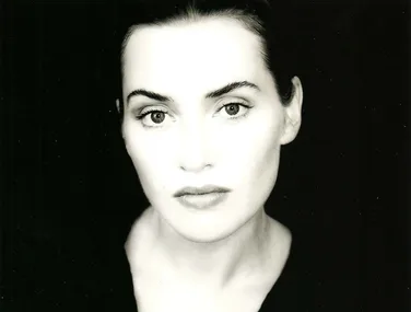 Black and white portrait of a woman gazing directly at the camera.
