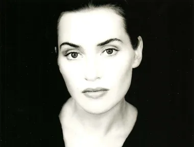 Black and white portrait of a woman gazing directly at the camera.