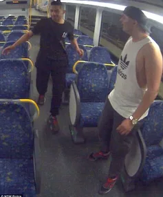 Two men standing inside a mostly empty train, captured by a surveillance camera.