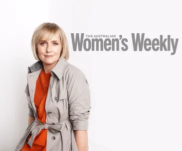 Female in gray coat over orange top, sitting against a white background, "The Australian Women's Weekly" text behind.