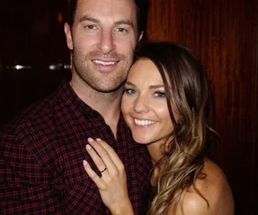 Couple embracing and smiling in a warmly lit room.