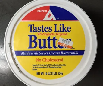 Container labeled "Tastes Like Butter" with "No Cholesterol" note and price sticker on the lid.