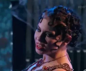 Bindi Irwin performs a dramatic tango on "Dancing with the Stars" with dark, curled hair and a glamorous outfit.