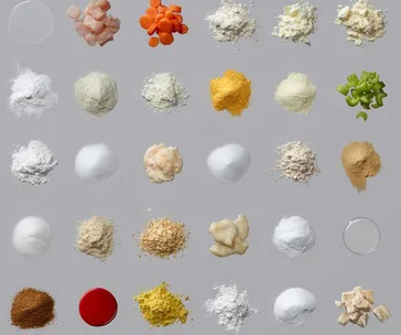 Various powdered and chopped food additives arranged in a grid on a grey background.