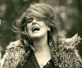 Singer passionately performing outdoors, wind in hair, wearing a fur coat.