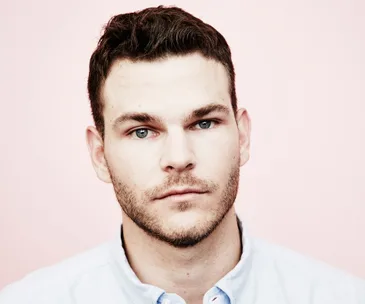 Portrait of a man with short hair and a trimmed beard, looking directly at the camera with a neutral expression.