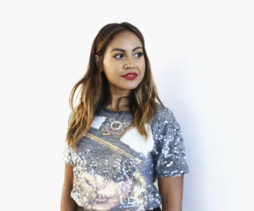 Jessica Mauboy in a sequin top, looking to the side against a white background.