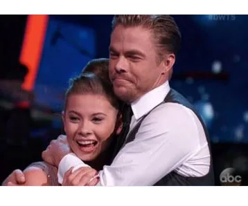 Bindi Irwin and her dance partner celebrate joyously on a dance show stage.