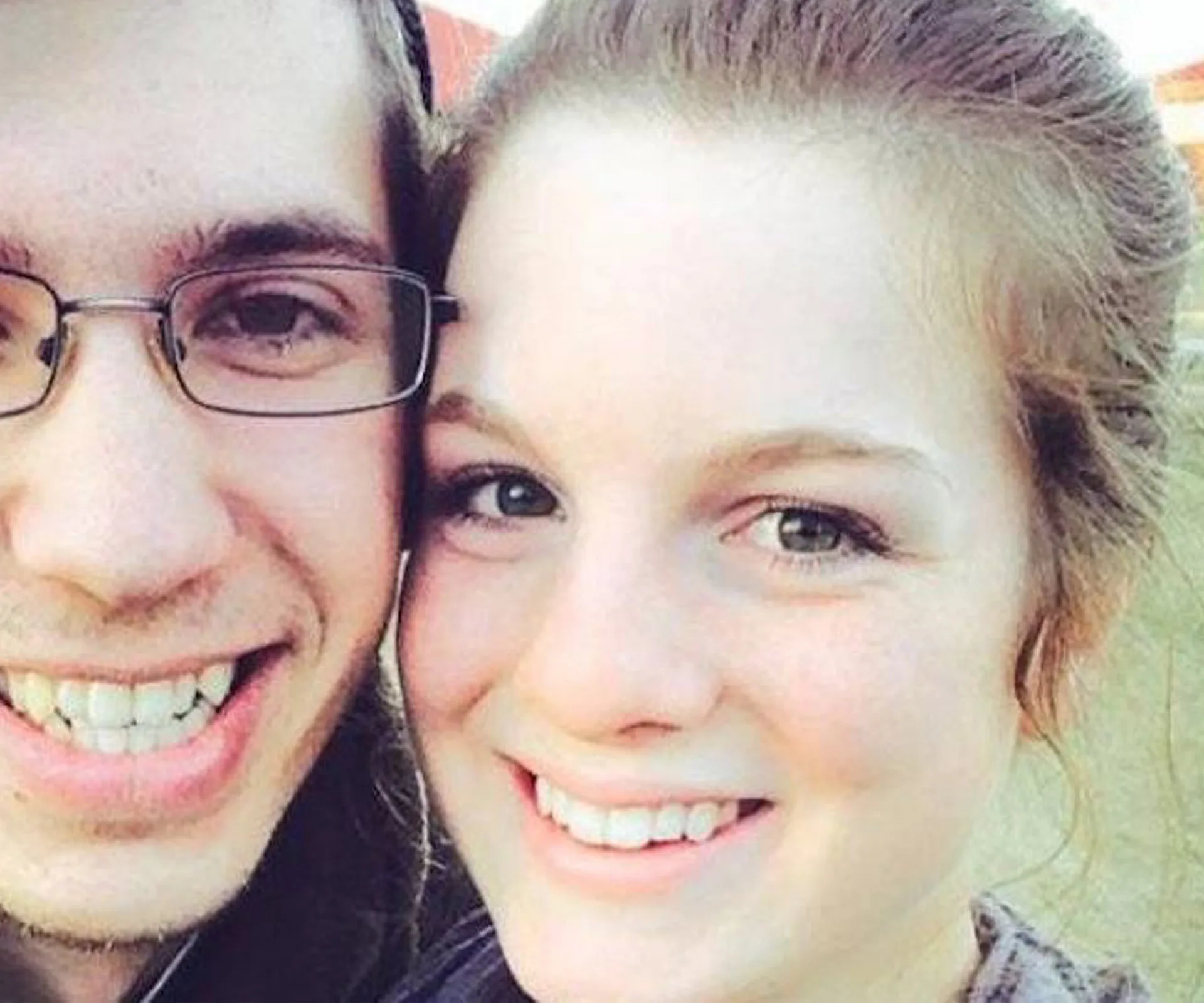 Two people smiling closely at the camera.