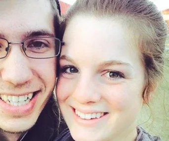 Two people smiling closely at the camera.