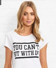 Young woman wearing a white shirt with the phrase "You Can't Sit With Us" printed in bold letters.