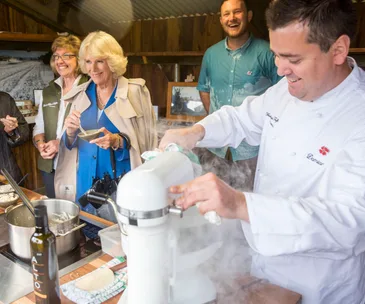 People enjoy truffle tasting in a kitchen setting with a chef preparing food.