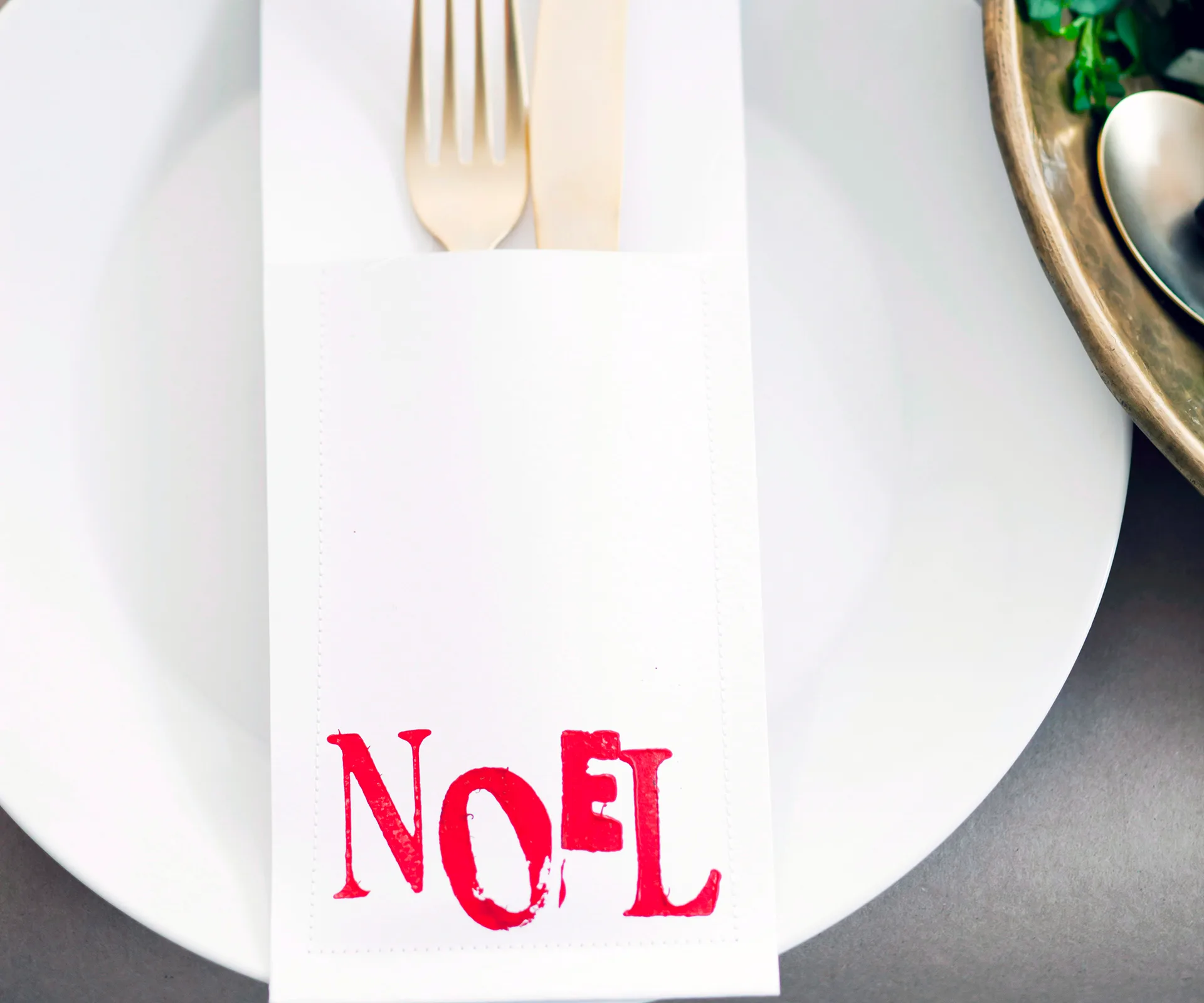 Christmas cutlery holder on a white plate with "Noel" in red text.
