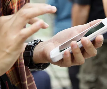 Person using a smartphone, swiping on an app.